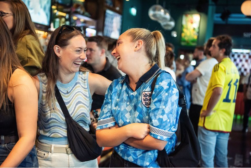women in football shirts laughing
